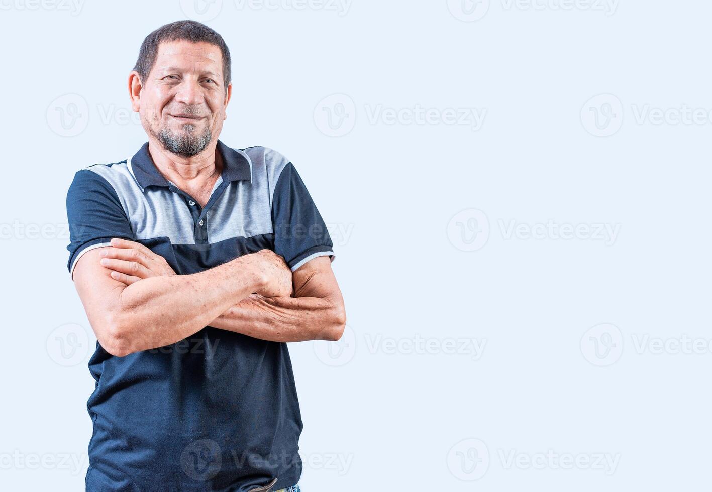 ritratto di sorridente anziano uomo con braccia attraversato isolato. sorridente latino vecchio uomo con braccia attraversato, casuale su isolato sfondo foto