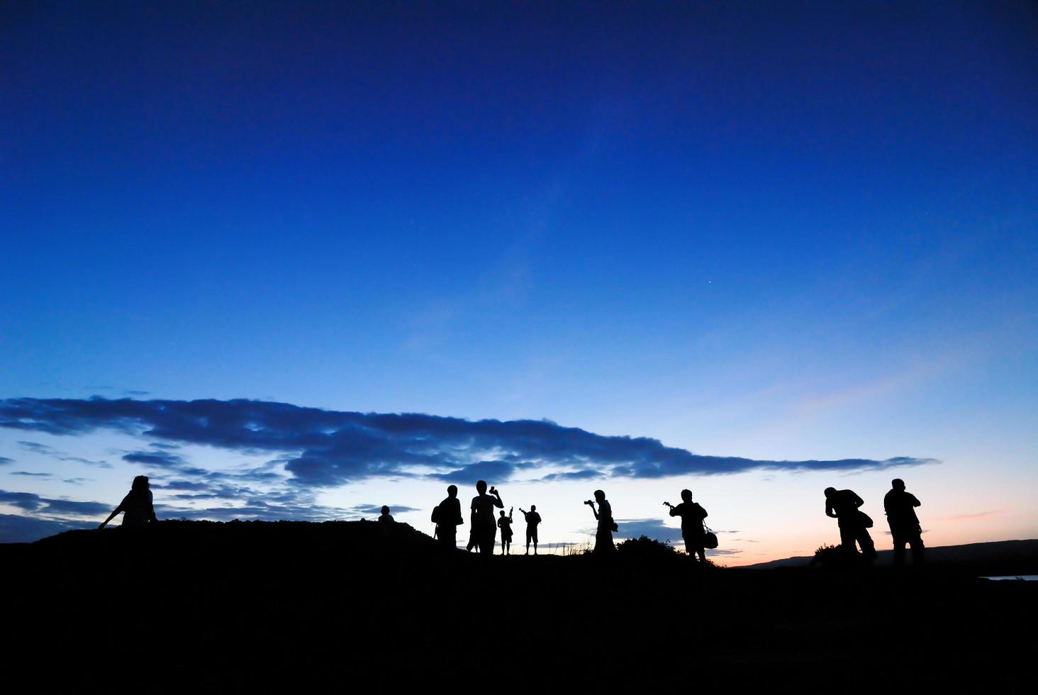 sagoma del fotografo che fotografa il paesaggio durante l'alba foto