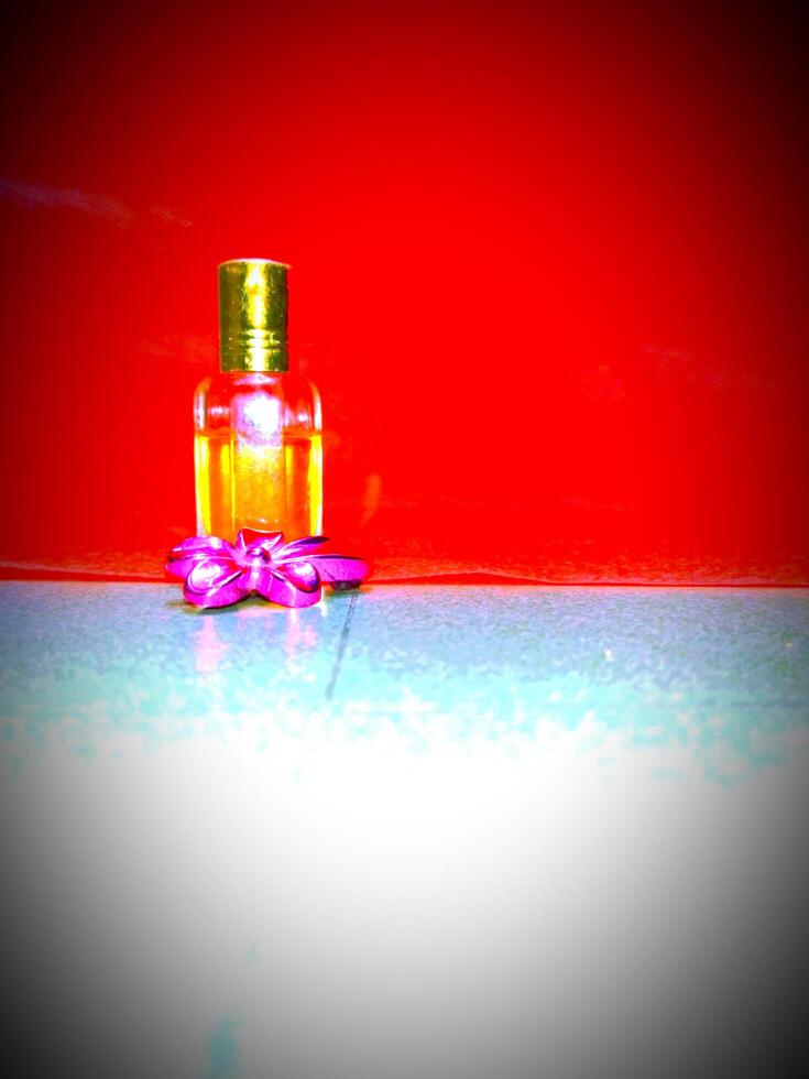 un' piccolo bottiglia di profumo seduta su un' rosso stoffa foto