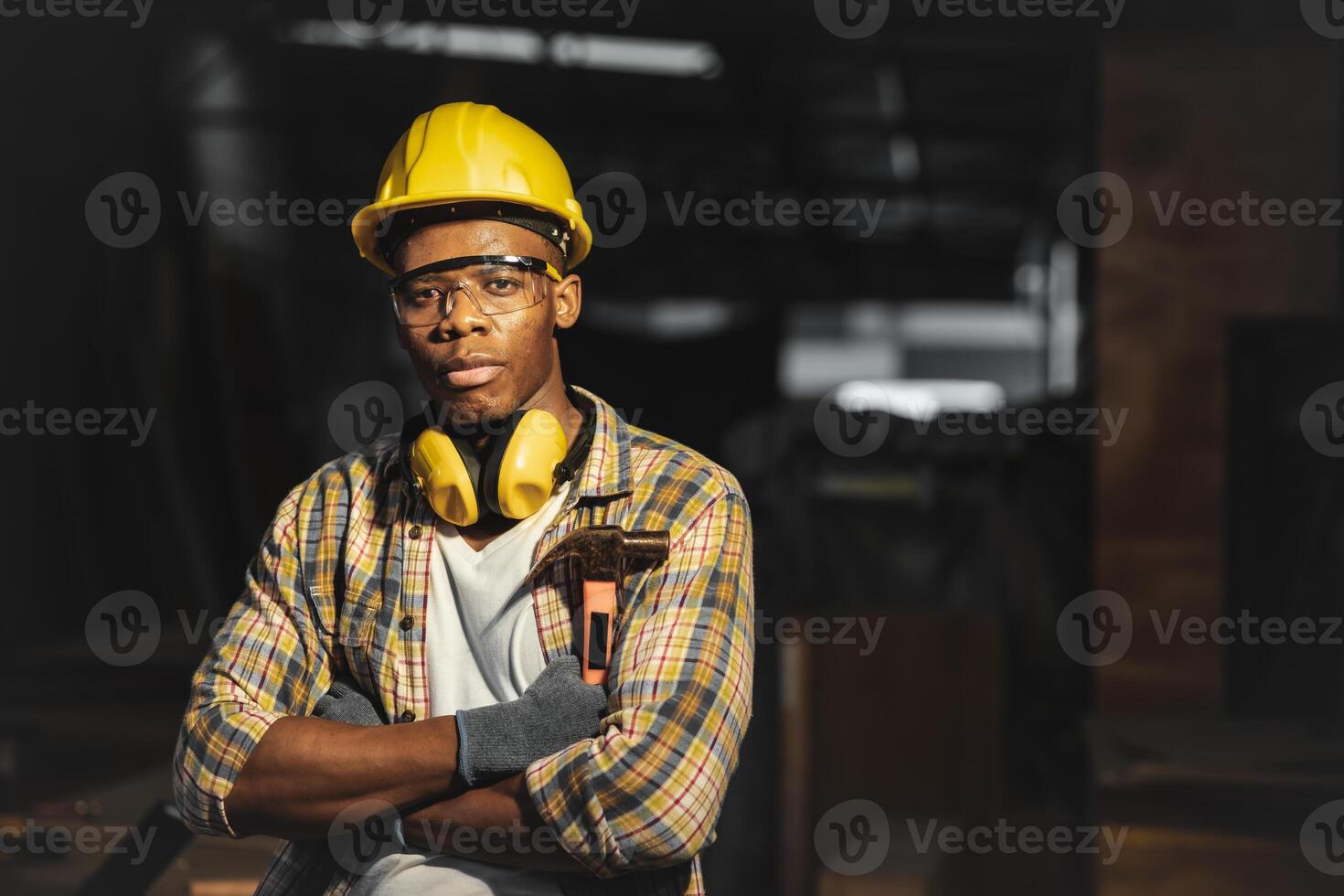 nero lavoratore maschio giovane fiducioso inteligente braccio attraversato per costruttore maneggevole uomo professionale opera foto