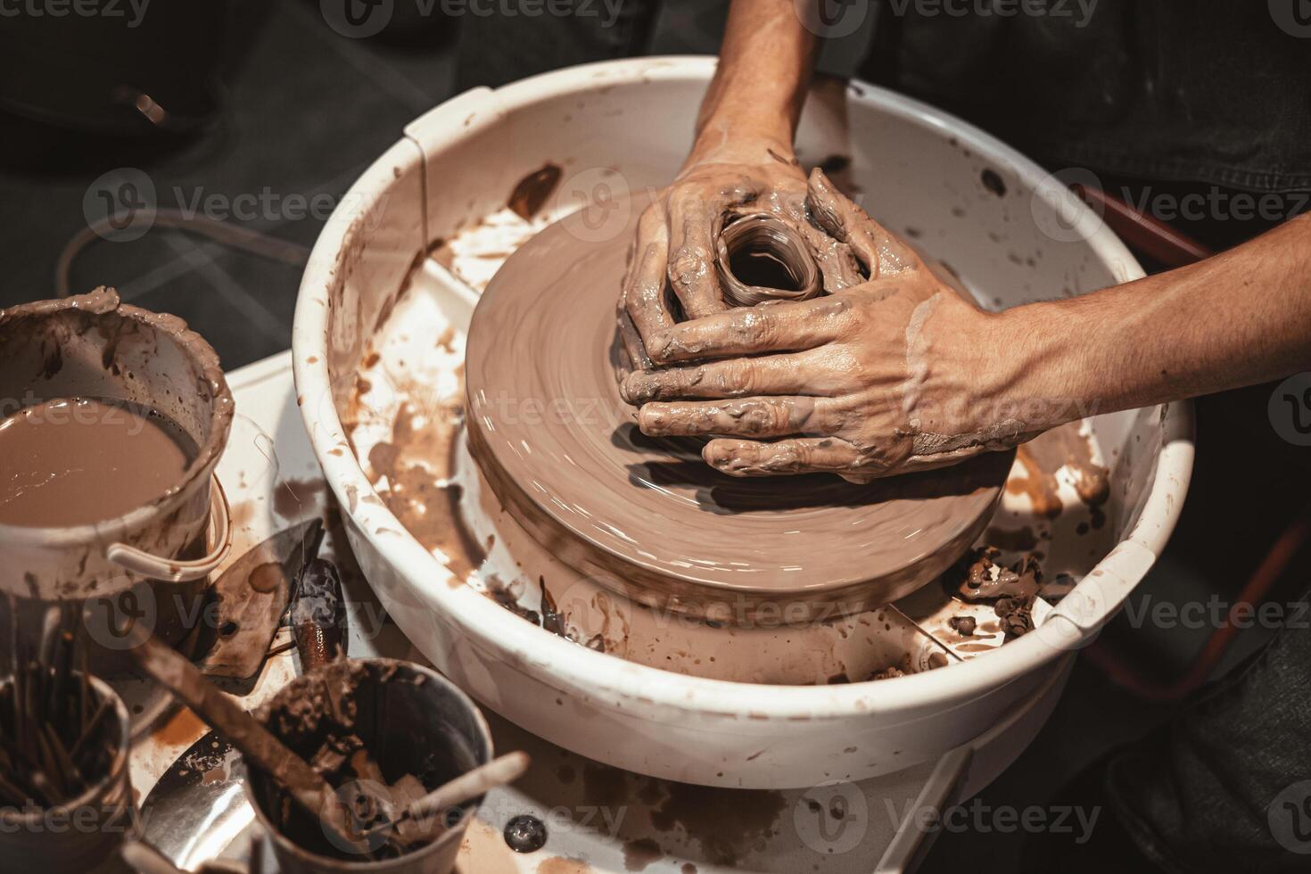 maestro di ceramica artigianato opera modellismo mano fatto argilla su vasaio ruota nel ceramica laboratorio foto