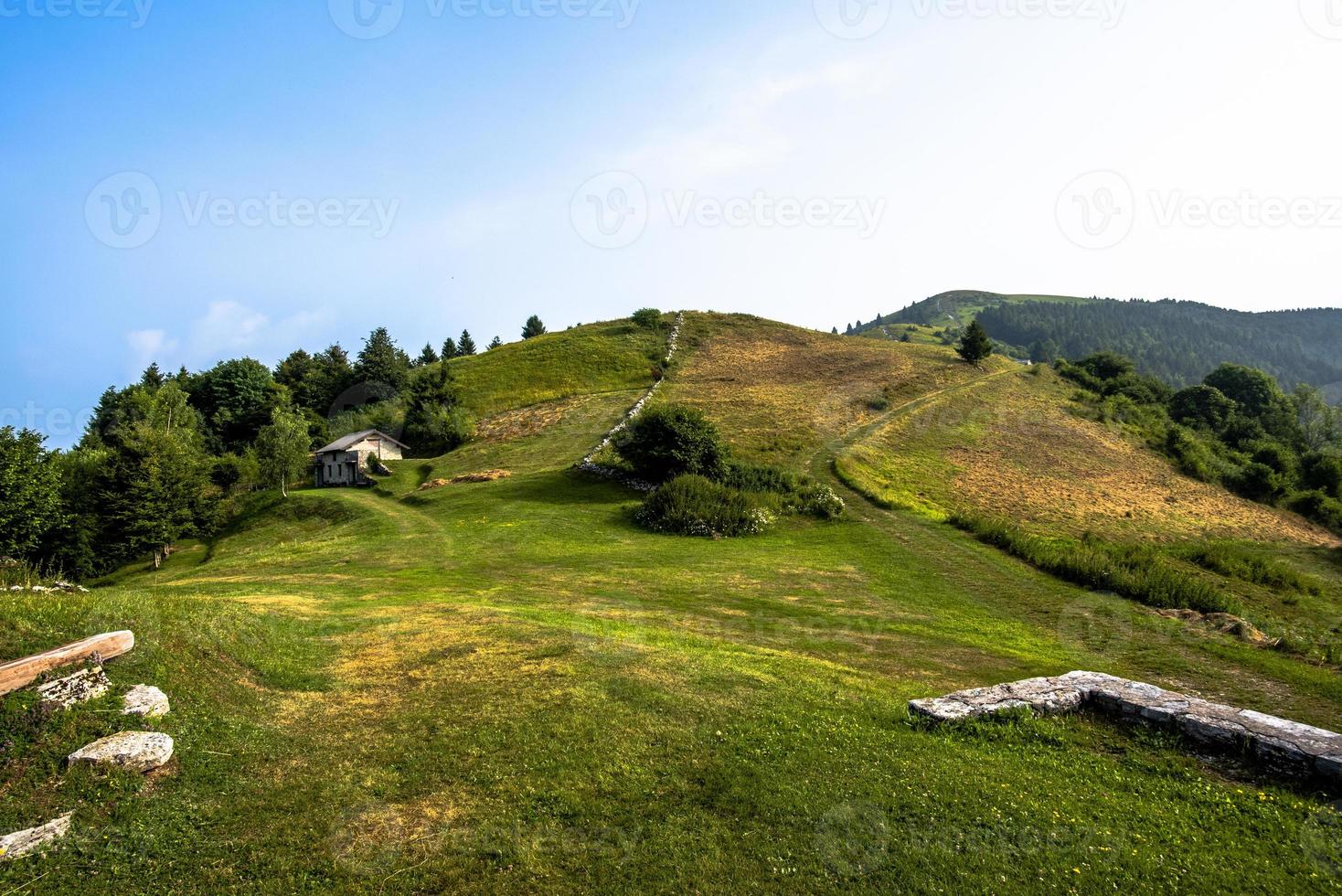 rifugio in pietra tra i verdi prati in montagna foto