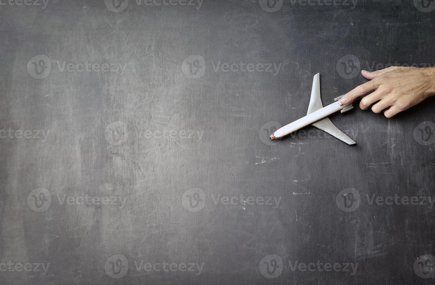 giocattolo aereo al di sopra di un' grigio vuoto tavola modello, turistico viaggio concetto sfondo foto