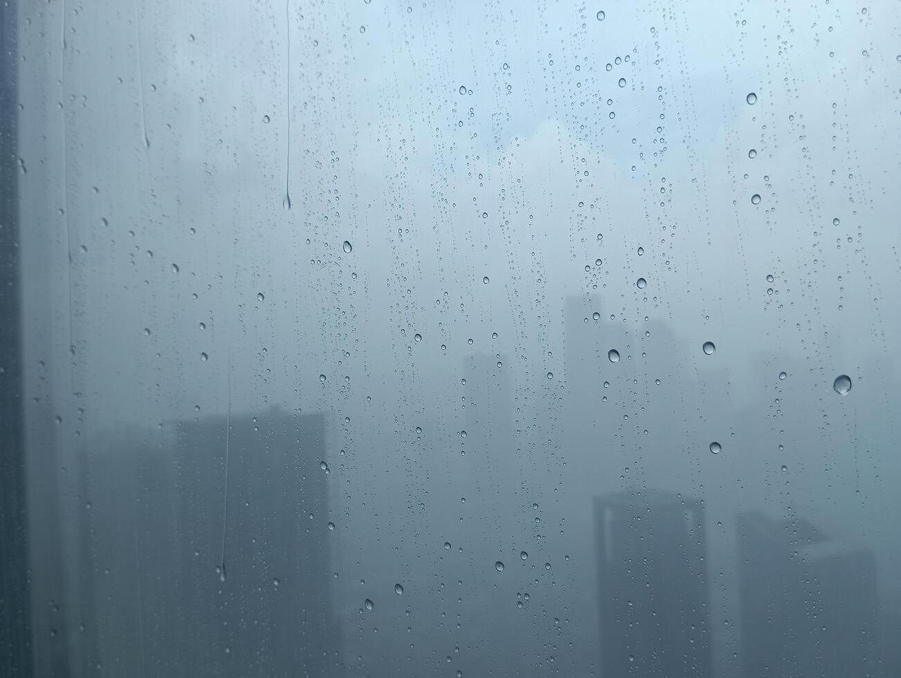 sfocato Visualizza con acqua gocce su il finestra di il grattacielo edifici foto