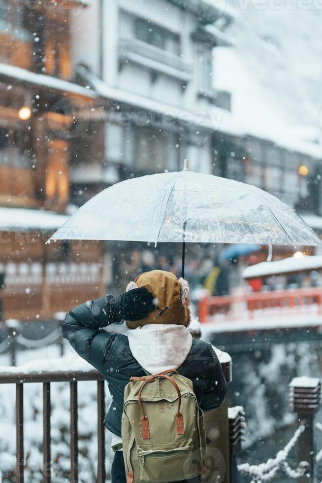 donna turista visitare ginzan onsen nel yamagata, contento viaggiatore giro turistico giapponese onsen villaggio con neve nel inverno stagione. punto di riferimento e popolare per attrazione nel Giappone. viaggio e vacanza concetto foto