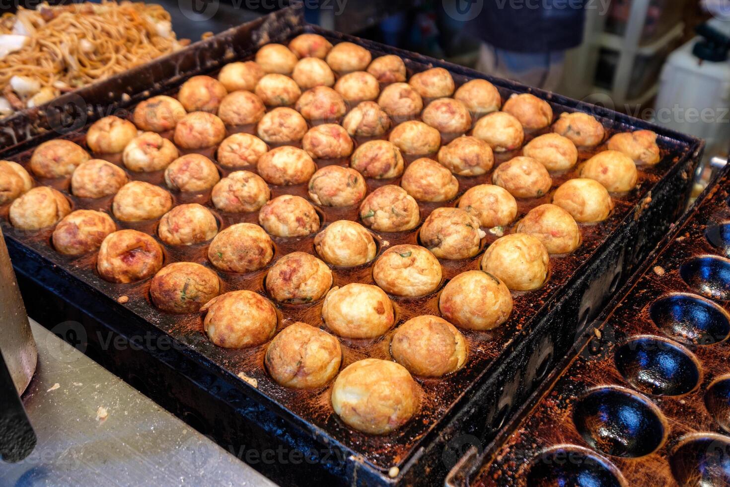 cucinando takoyaki grigliate su acciaio padella, tradizionale giapponese cibo foto