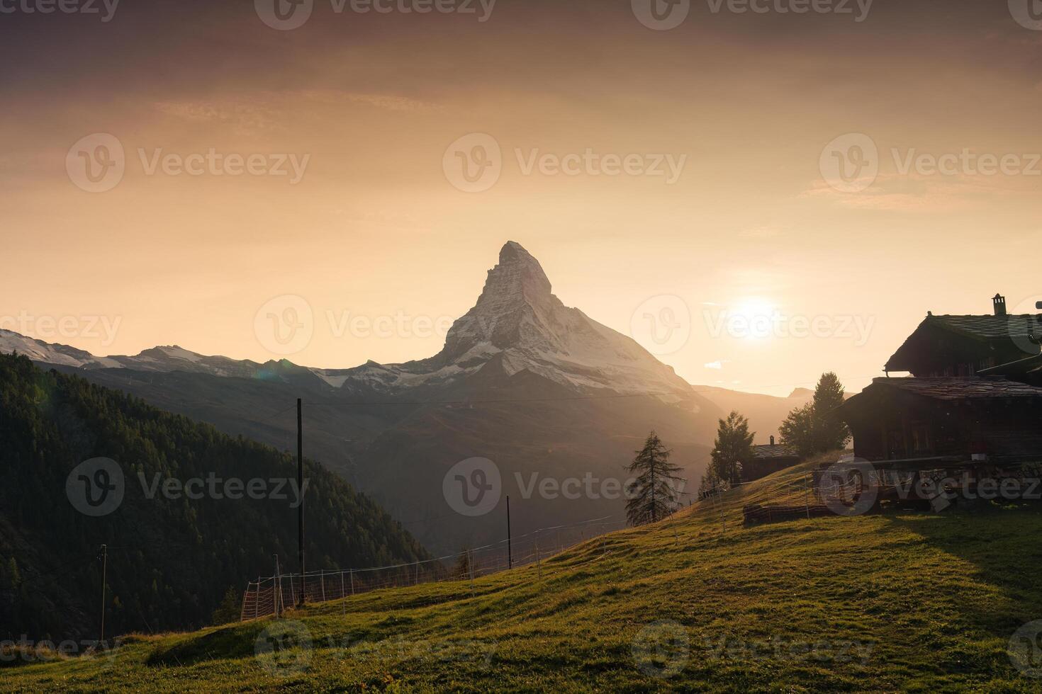 tramonto al di sopra di Cervino montagna con di legno Villetta su pascolo nel rurale scena a Zermatt, Svizzera foto