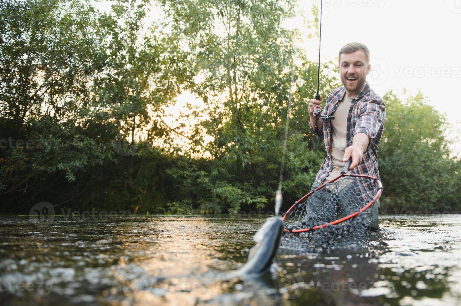 pescatore catture un' trota su il fiume nel estate foto