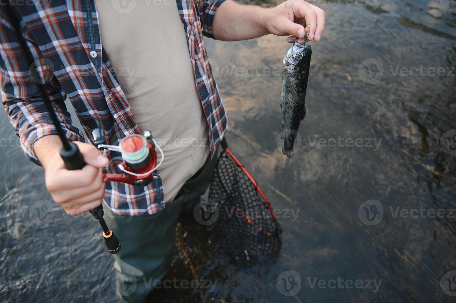 pescatore a mosca Tenere trota su di il acqua foto