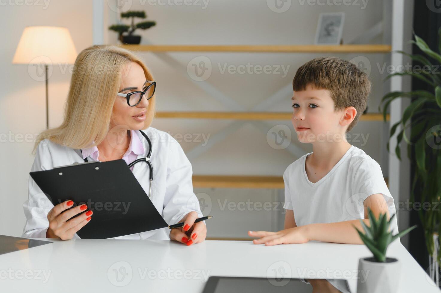 sorridente giovane femmina medico o pediatra parlare comfort piccolo ragazzo paziente a consultazione nel privato clinica. cura donna gp supporto rallegrare poco ragazzo esaminare consultare nel Ospedale. assistenza sanitaria concetto. foto