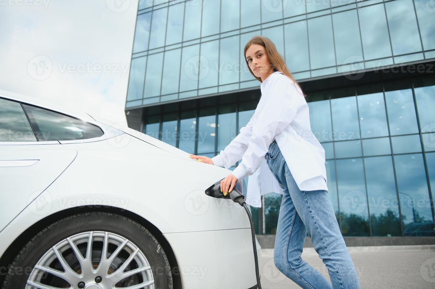 ragazza ricarica elettro auto a il elettrico gas stazione foto