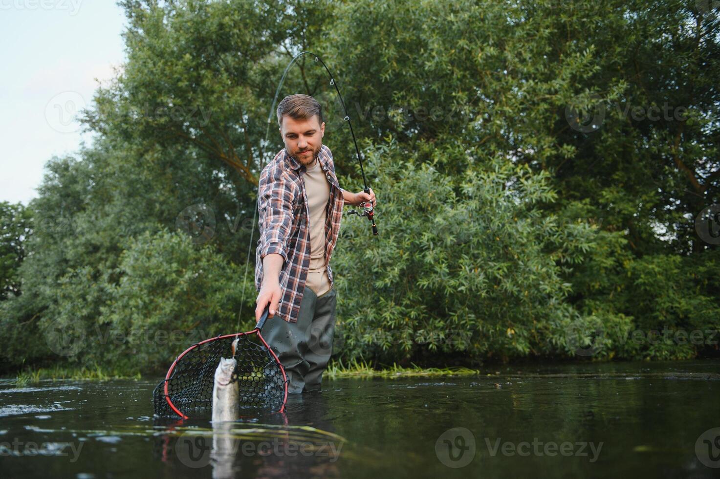 pescatore raccolta su grande arcobaleno trota a partire dal il suo pesca netto foto