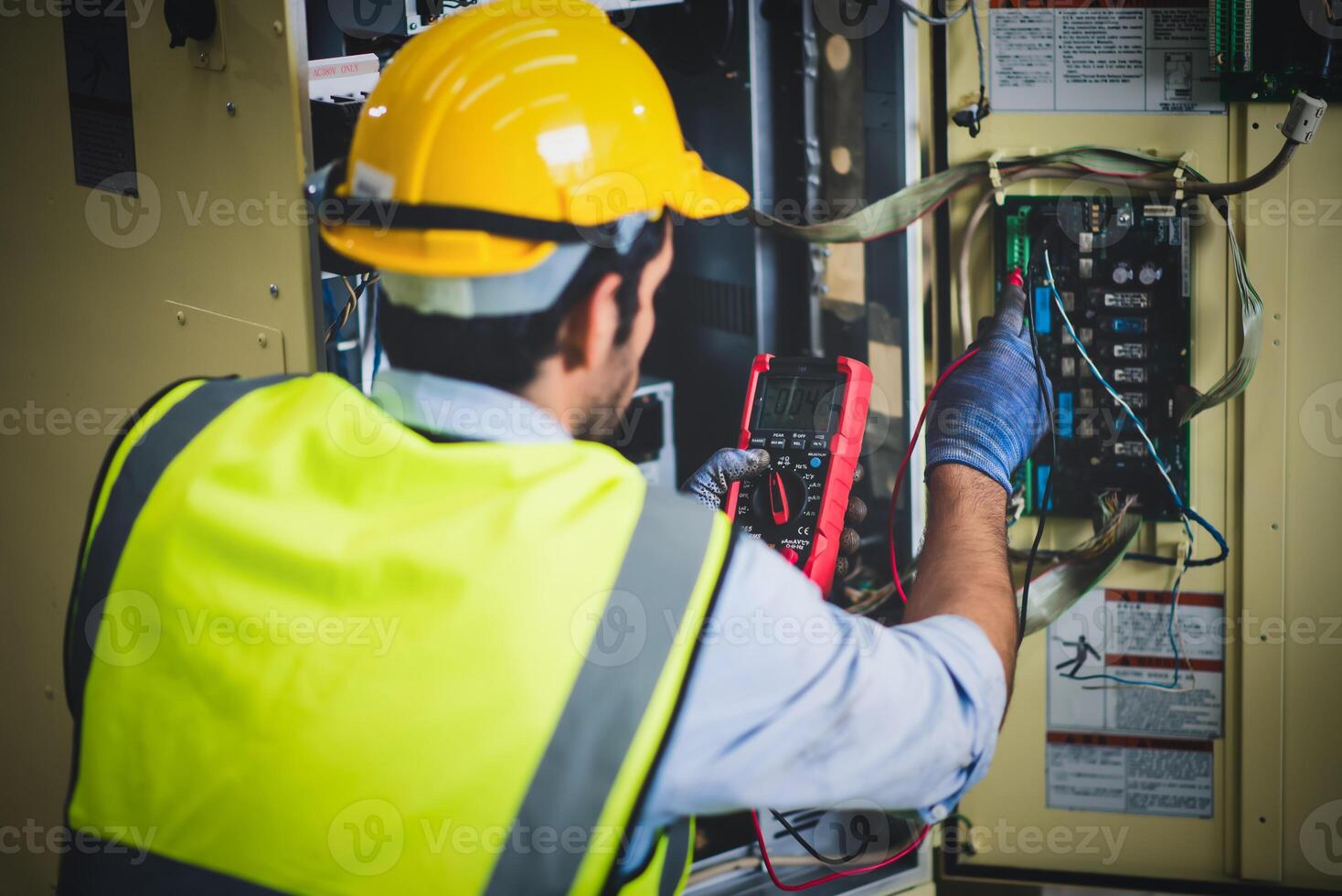 elettrico ingegnere opera tester misurazione voltaggio e attuale di energia elettrico linea nel elettrico Consiglio dei ministri controllo per industriale produzione. foto