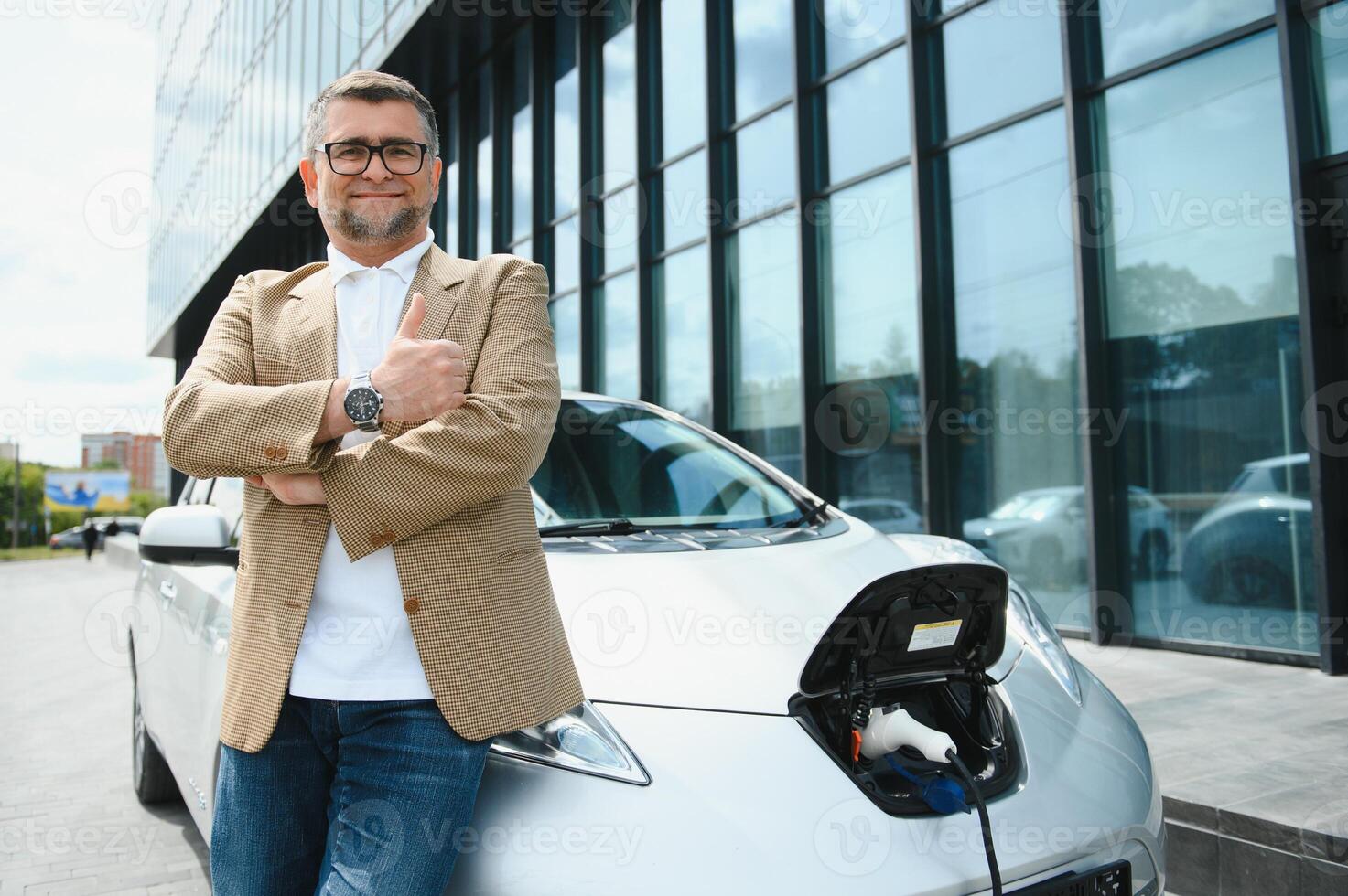 uomo addebiti un elettrico auto a il ricarica stazione foto