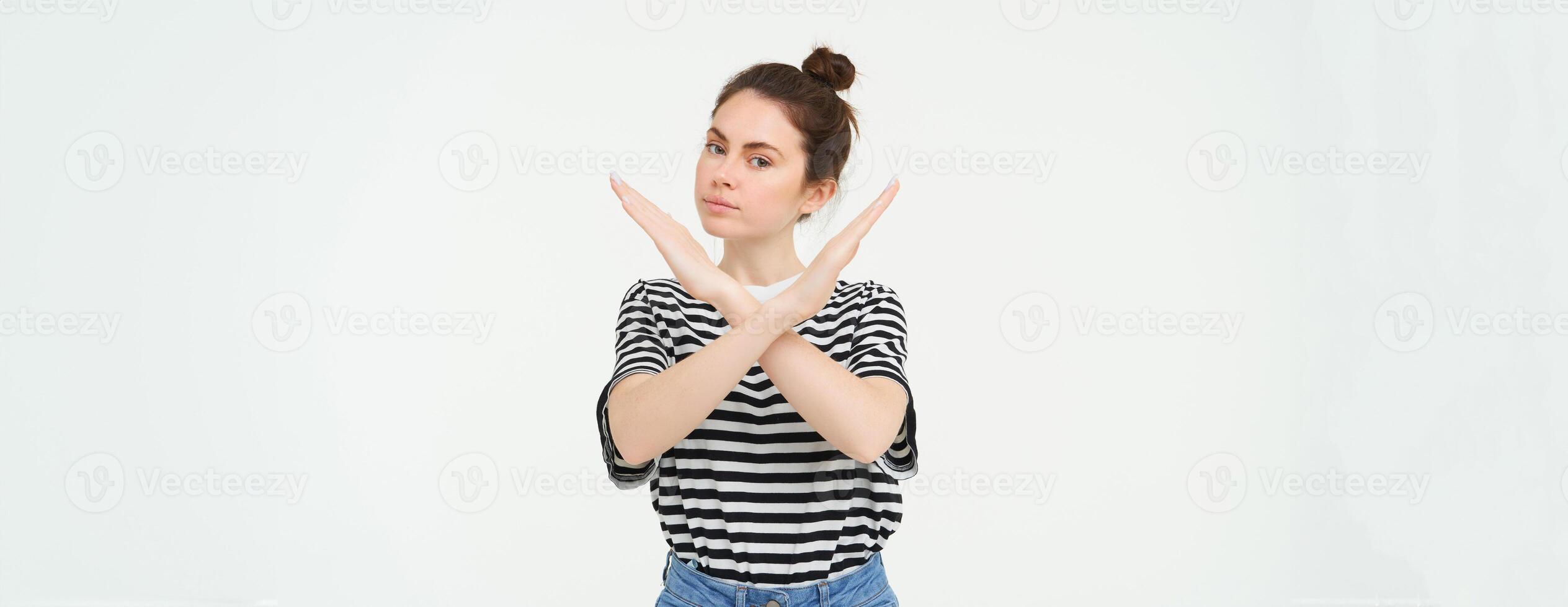 ritratto di fiducioso giovane donna, mostrando attraversare cartello, vietare gesto, disapprovare qualche cosa, isolato contro bianca sfondo foto