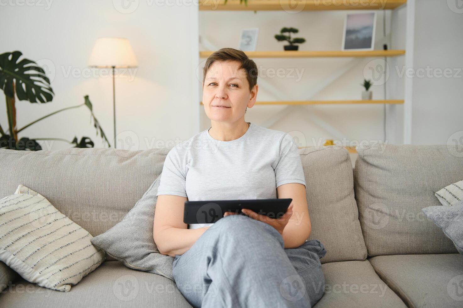 le persone, tecnologia e Internet concetto - contento mezzo anziano donna con tavoletta pc computer a casa. foto