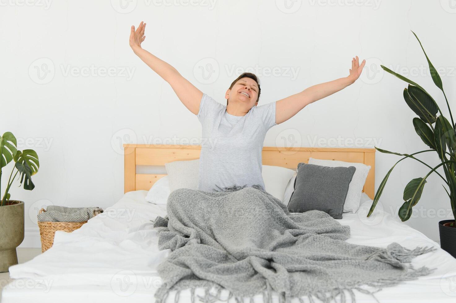 attraente mezzo anziano donna veglia su nel letto. foto