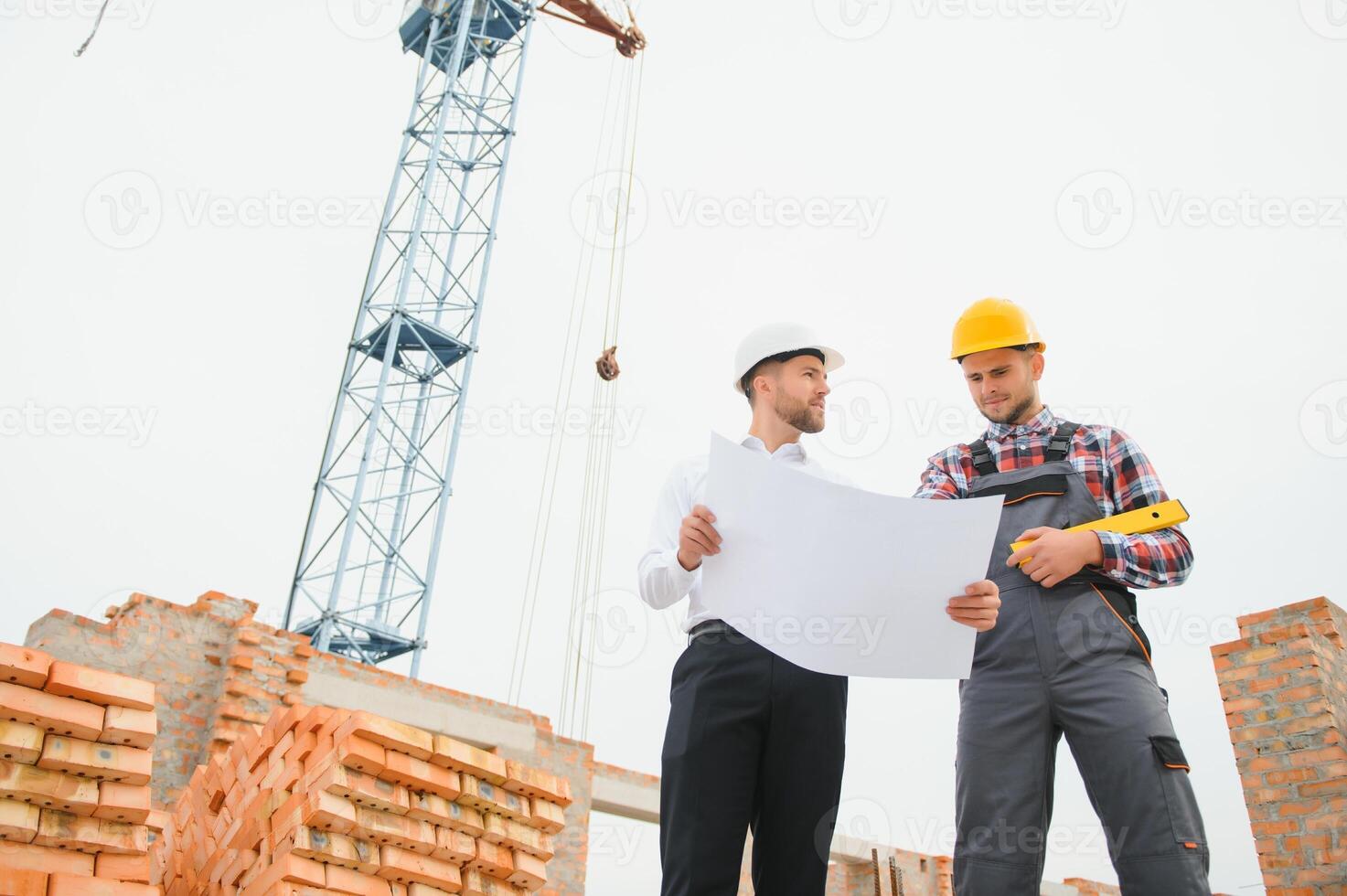 strutturale ingegnere e caposquadra lavoratore discutere, Piano Lavorando per il all'aperto edificio costruzione luogo foto