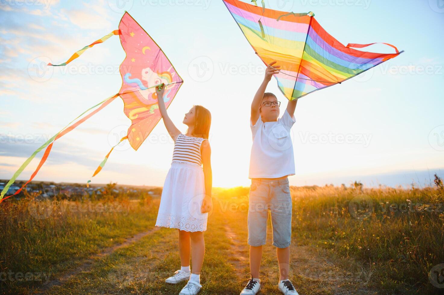 bambini lanciare un' aquilone nel il campo a tramonto foto