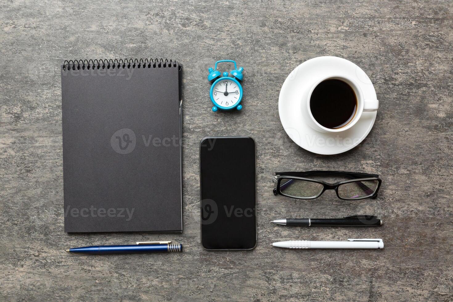 moderno ufficio scrivania tavolo con taccuino, smartphone e altro forniture con tazza di caffè. vuoto taccuino pagina per voi design. superiore Visualizza, piatto posare foto