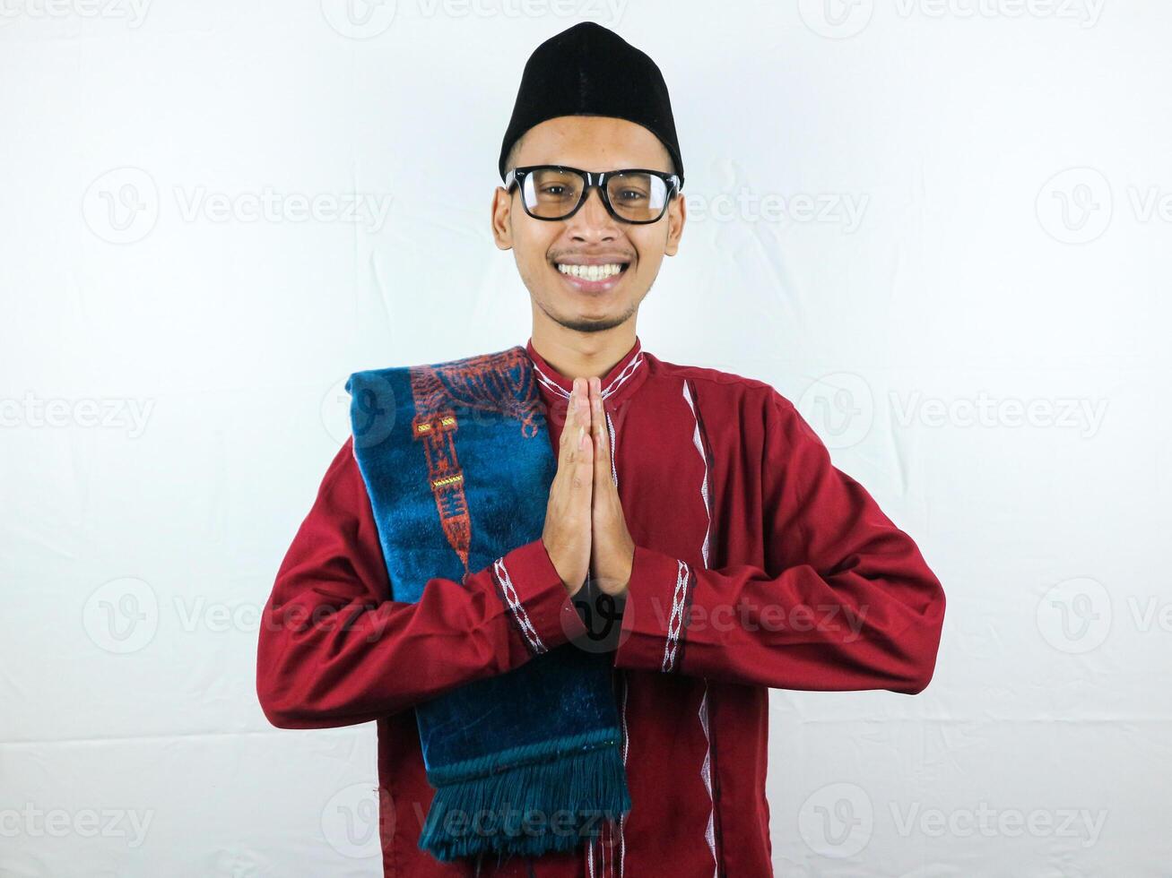 asiatico musulmano uomo indossare bicchieri sorridente per dare saluto durante Ramadan e eid al Fitr celebrazione al di sopra di bianca sfondo foto