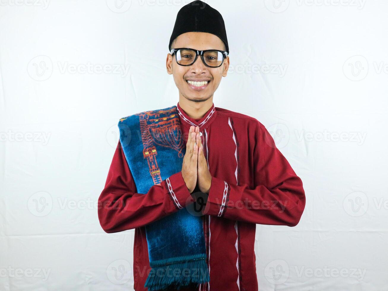 asiatico musulmano uomo indossare bicchieri sorridente per dare saluto durante Ramadan e eid al Fitr celebrazione al di sopra di bianca sfondo foto