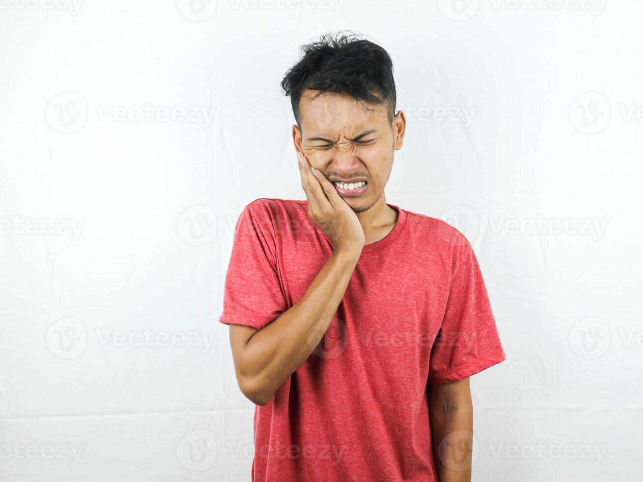 adulto asiatico uomo toccante il suo mascella, sensazione mal di denti isolato su bianca sfondo foto
