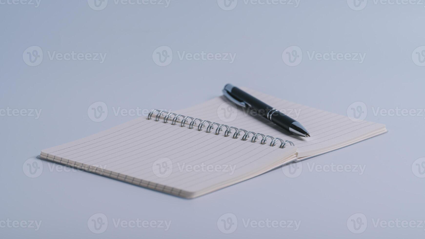 taccuino e penna vicino su con un' sfocato sfondo nel il primo piano su bianca tavolo sfondo foto