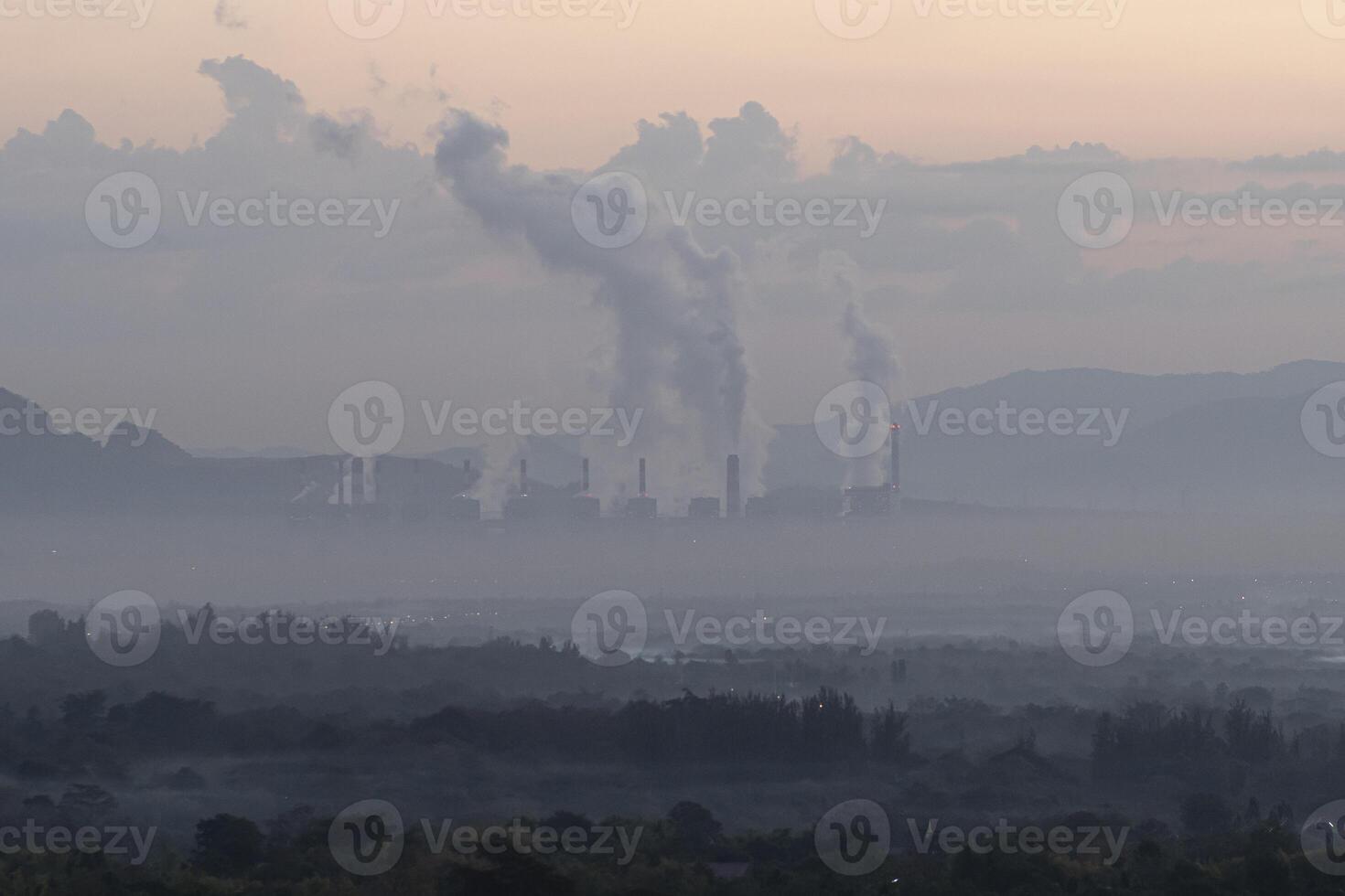 un' fabbrica emette Fumo a partire dal suo pile, e aria inquinamento al di sopra di il carbone energia pianta mae mah lampang nel il mattina con nebbia, adatto per industriale e ambientale temi foto