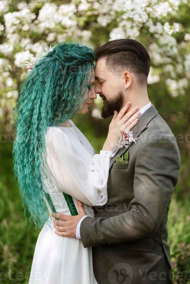 un' barbuto sposo e un' ragazza con verde capelli siamo a piedi foto