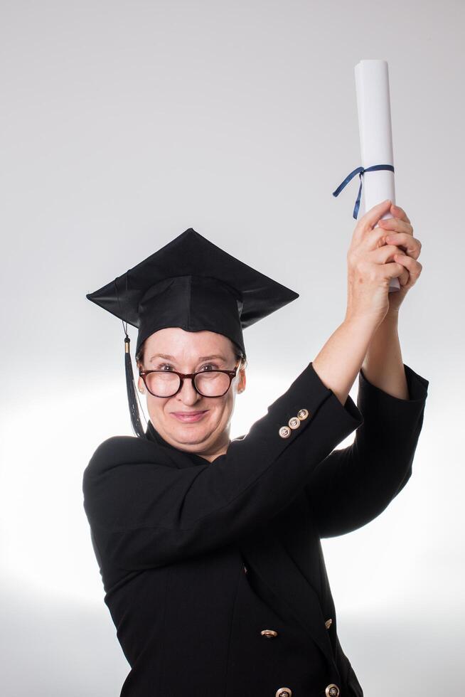 maturo donna con la laurea berretto mostrando sua certificato foto