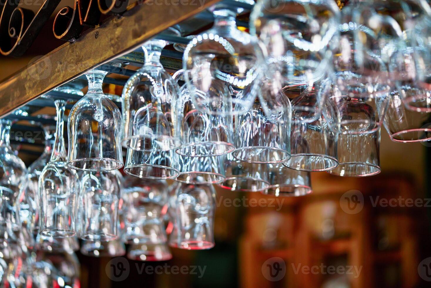 vuoto pulito bicchieri per Champagne sospeso al di sopra di il bar contatore. cristallo bicchieri per alcool sospeso nel il sbarra. avvicinamento foto