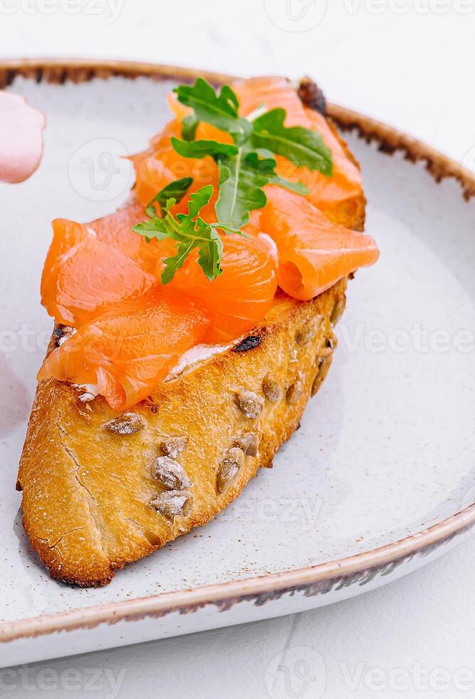 Bruschetta con salmone su piatto vicino su foto