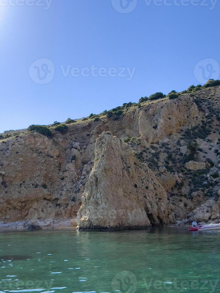 un' barca nel il acqua vicino un' roccioso scogliera foto