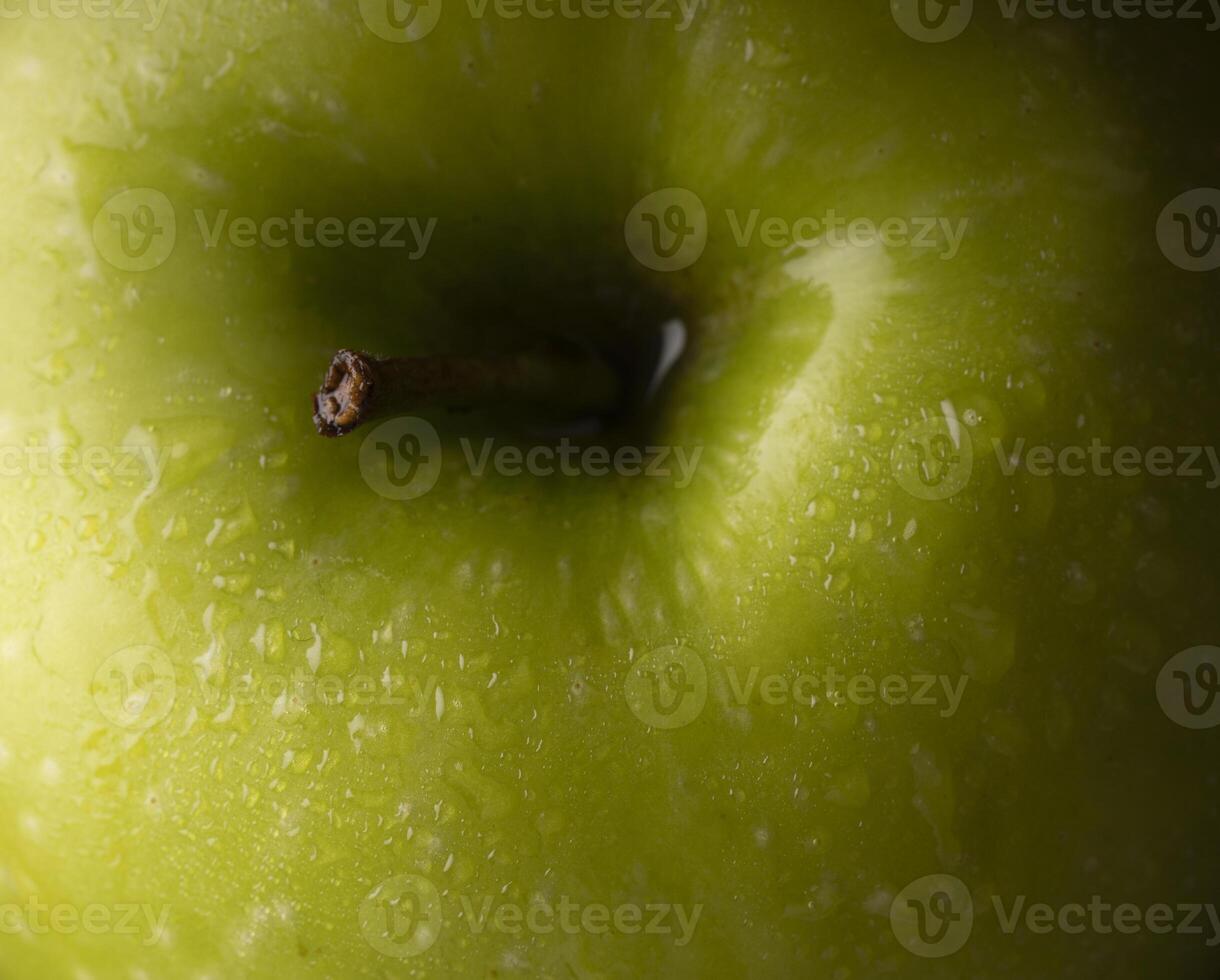 un' vicino su di un' verde Mela con acqua goccioline foto