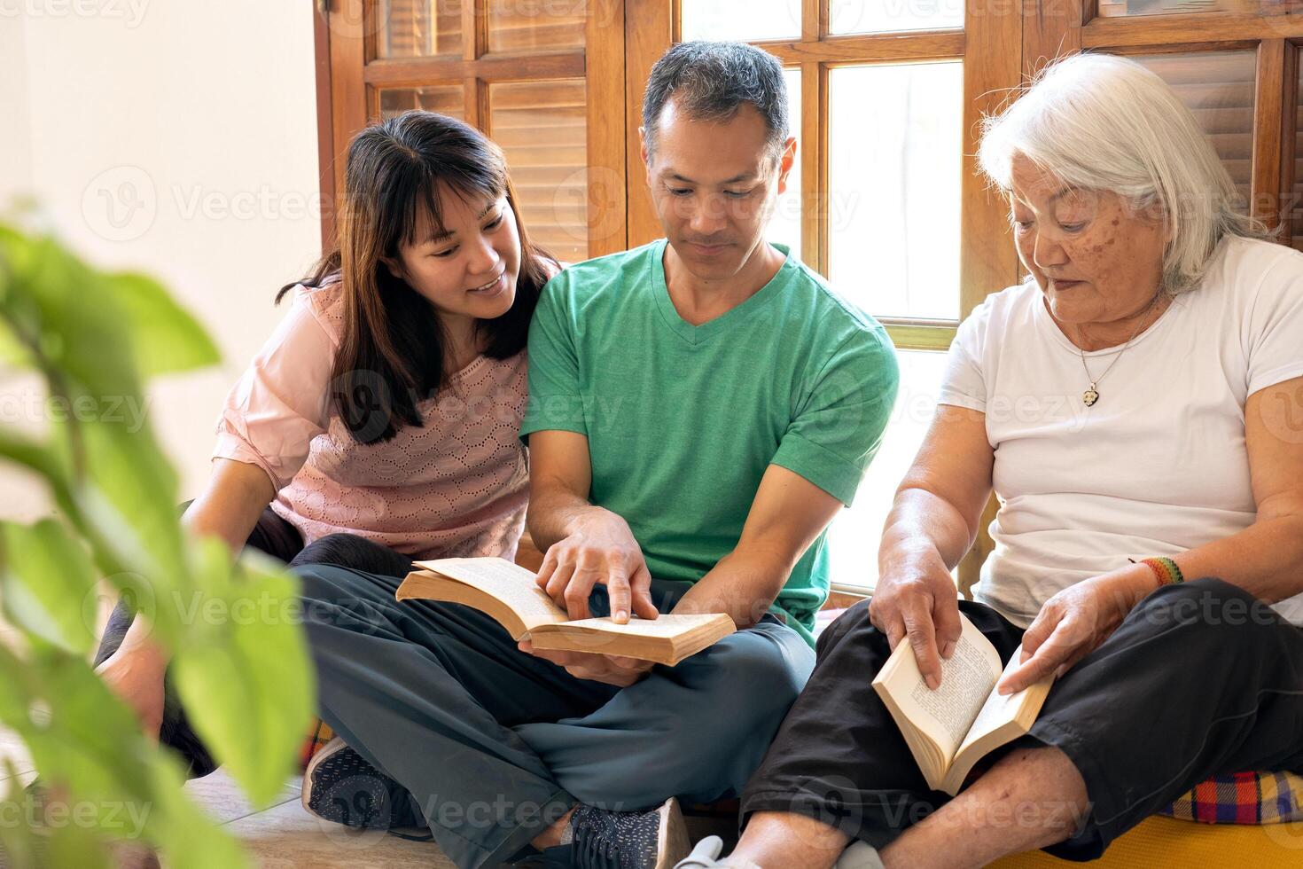 madre e adulto bambini di giapponese origine condivisione un' momento di lettura. foto