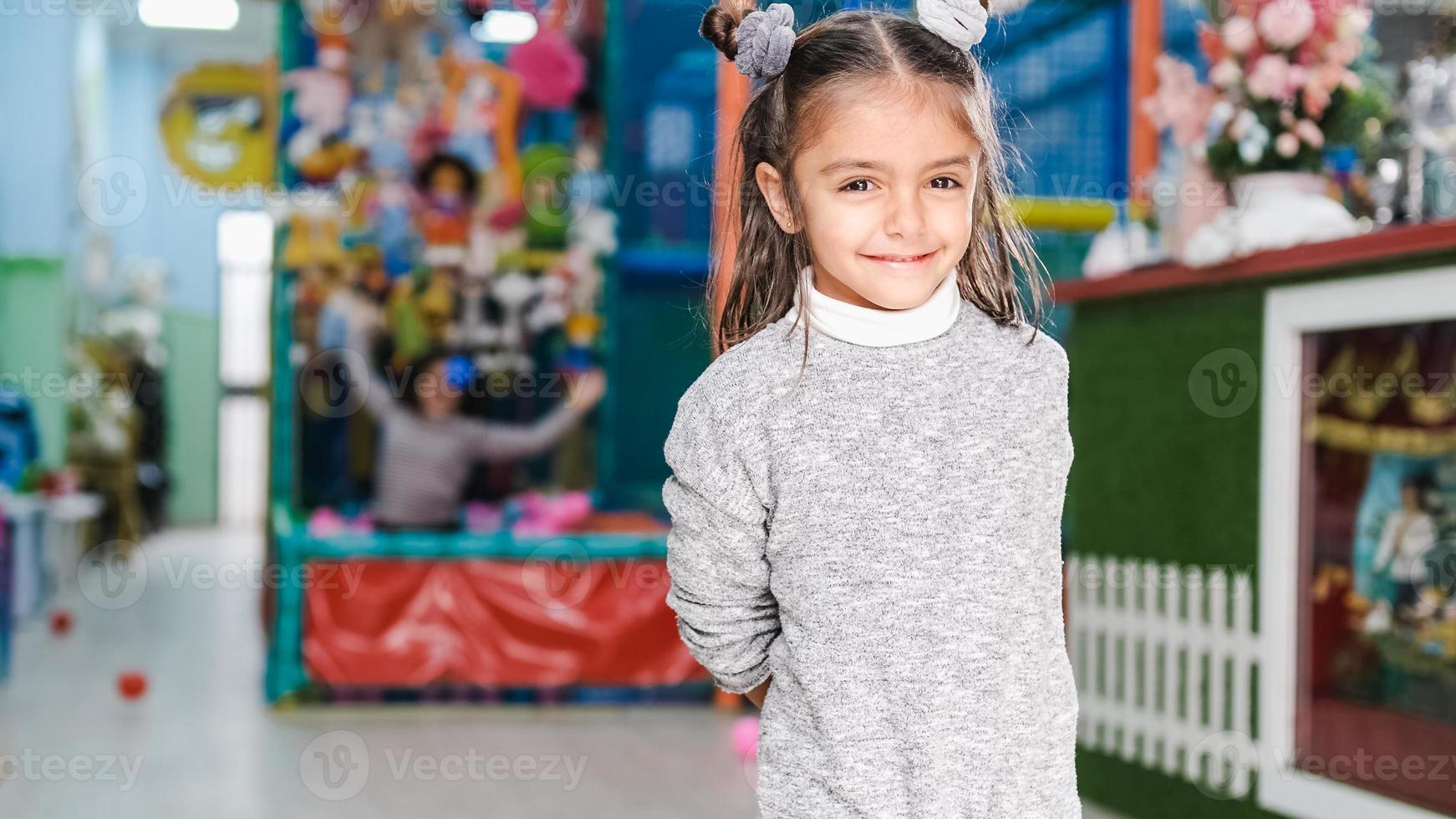 Bambina di 5 anni sorridente nel parco giochi per bambini foto