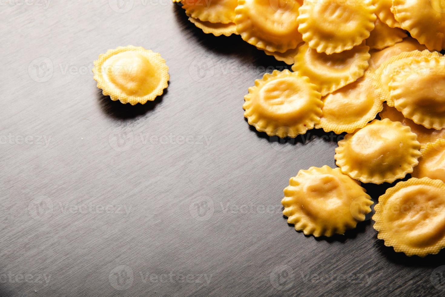 cucinare i ravioli italiani sulla tavola di legno. vista dall'alto con spazio di copia. foto