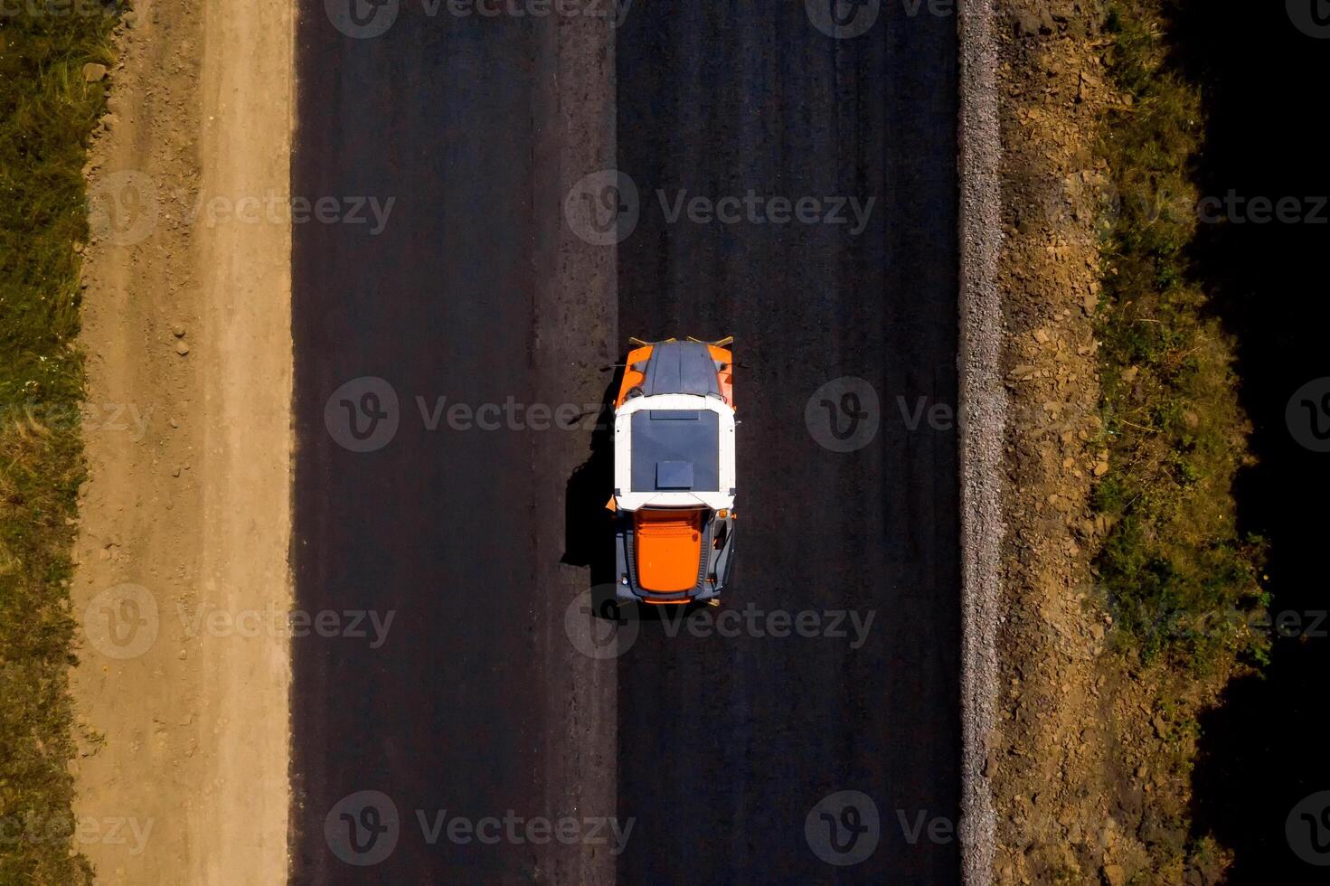 pesante vibrazione rullo a opera pavimentazione asfalto, strada riparare. strada rullo appiattimento nuovo asfalto. aereo Visualizza foto