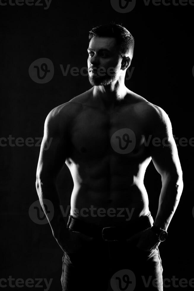 forte atletico uomo fitness modello. maschio mostrando sei imballare addominali. isolato su buio sfondo. nero e bianca foto. foto
