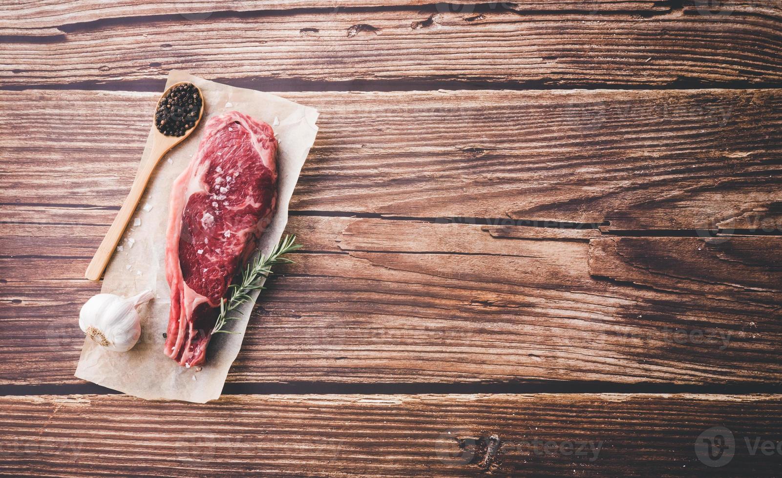 manzo crudo invecchiato a secco su fondo di legno. copia spazio foto