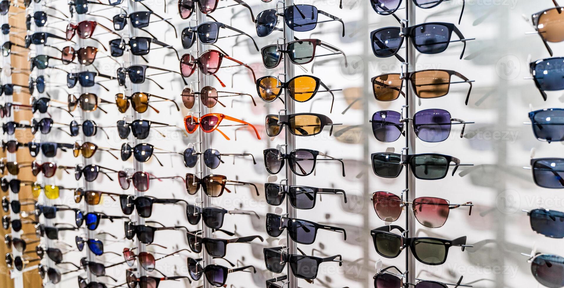 occhiali da sole nel il negozio Schermo scaffali. In piedi con bicchieri nel il memorizzare di ottica. foto