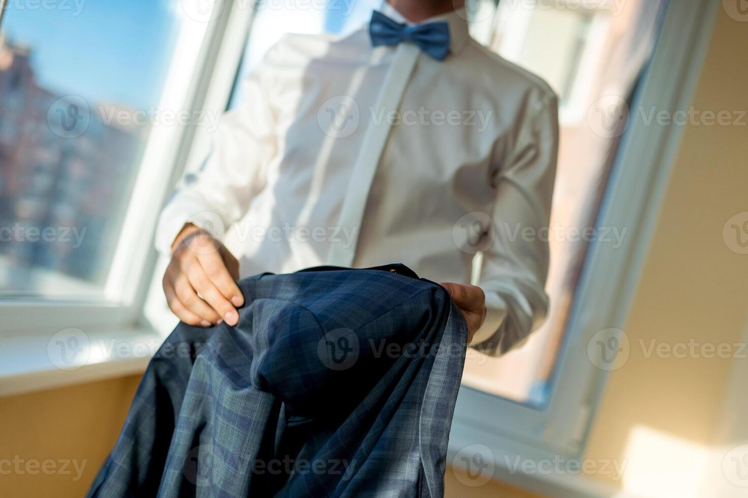 sposo sessione fotografica. uomo nel scacchi completo da uomo. nozze giorno. elegante sposo nel bianca camicia . blu arco legare. foto