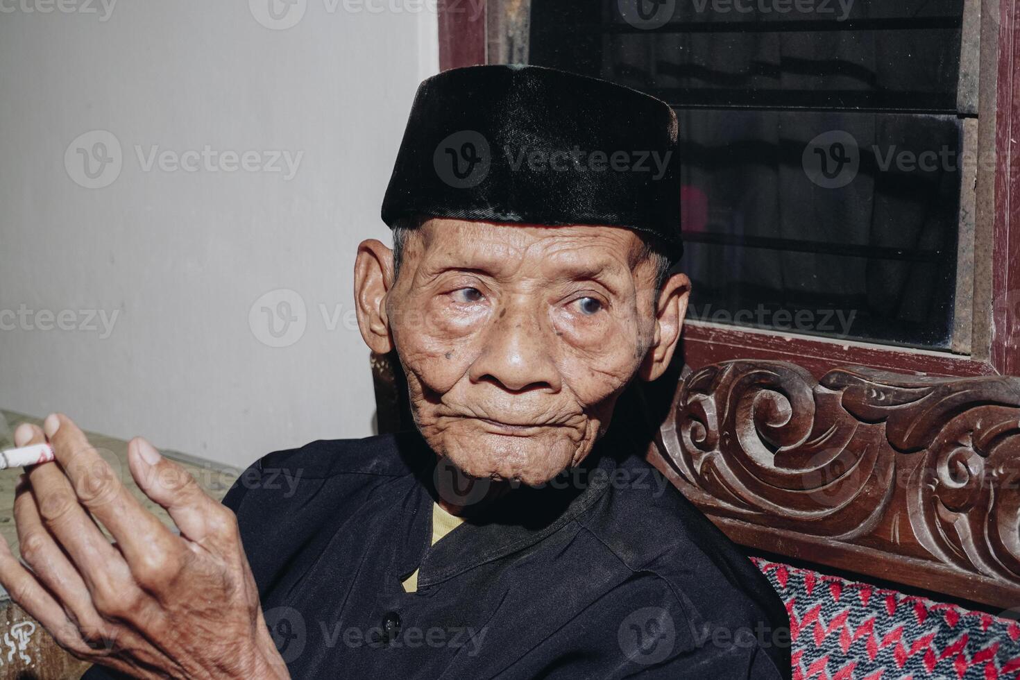 ritratto di un anziano asiatico uomo fumo un' sigaretta. foto