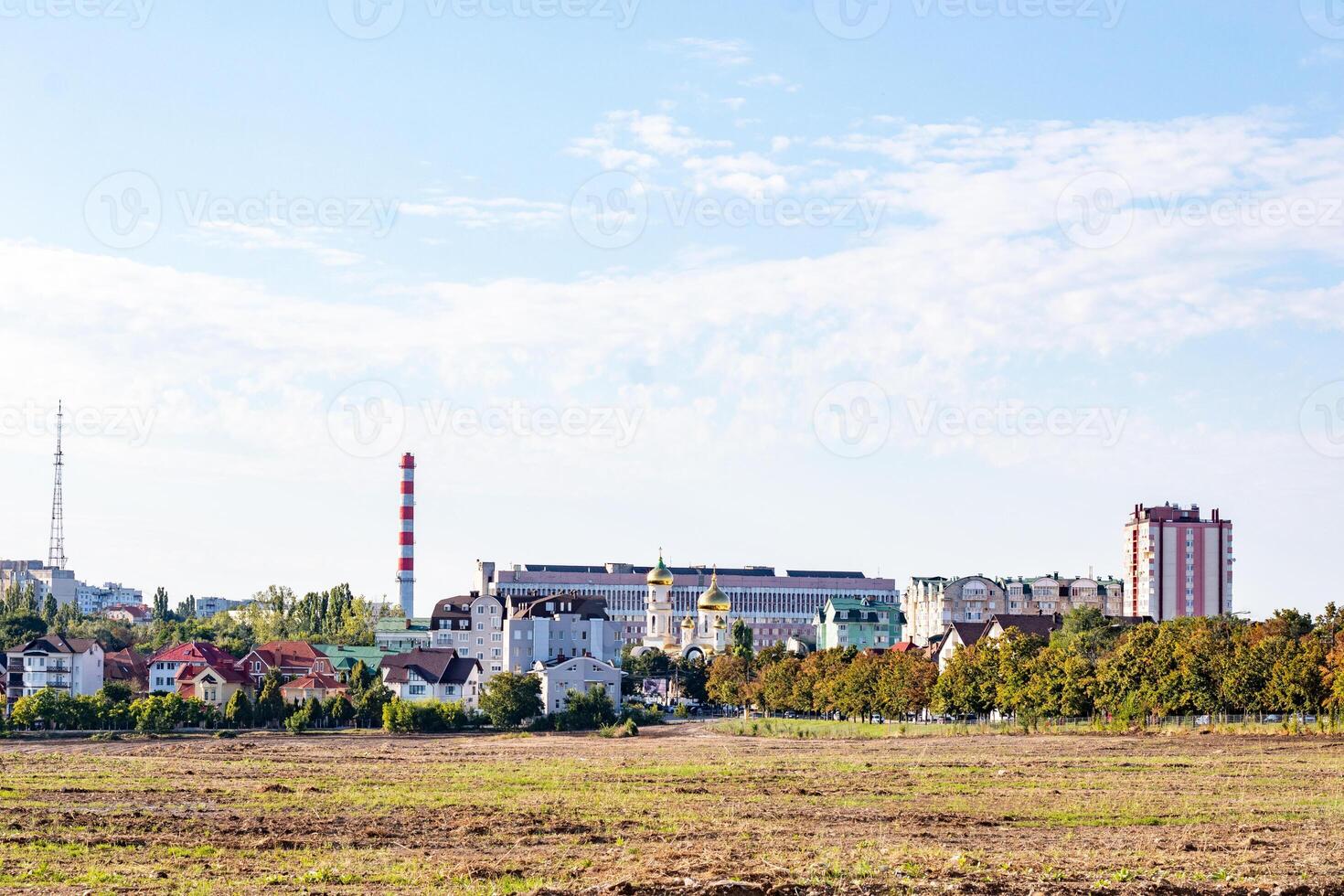 urbano paesaggio con industriale edifici, ciminiere, e Residenziale case contro un' chiaro blu cielo nel chisinau, moldova. foto