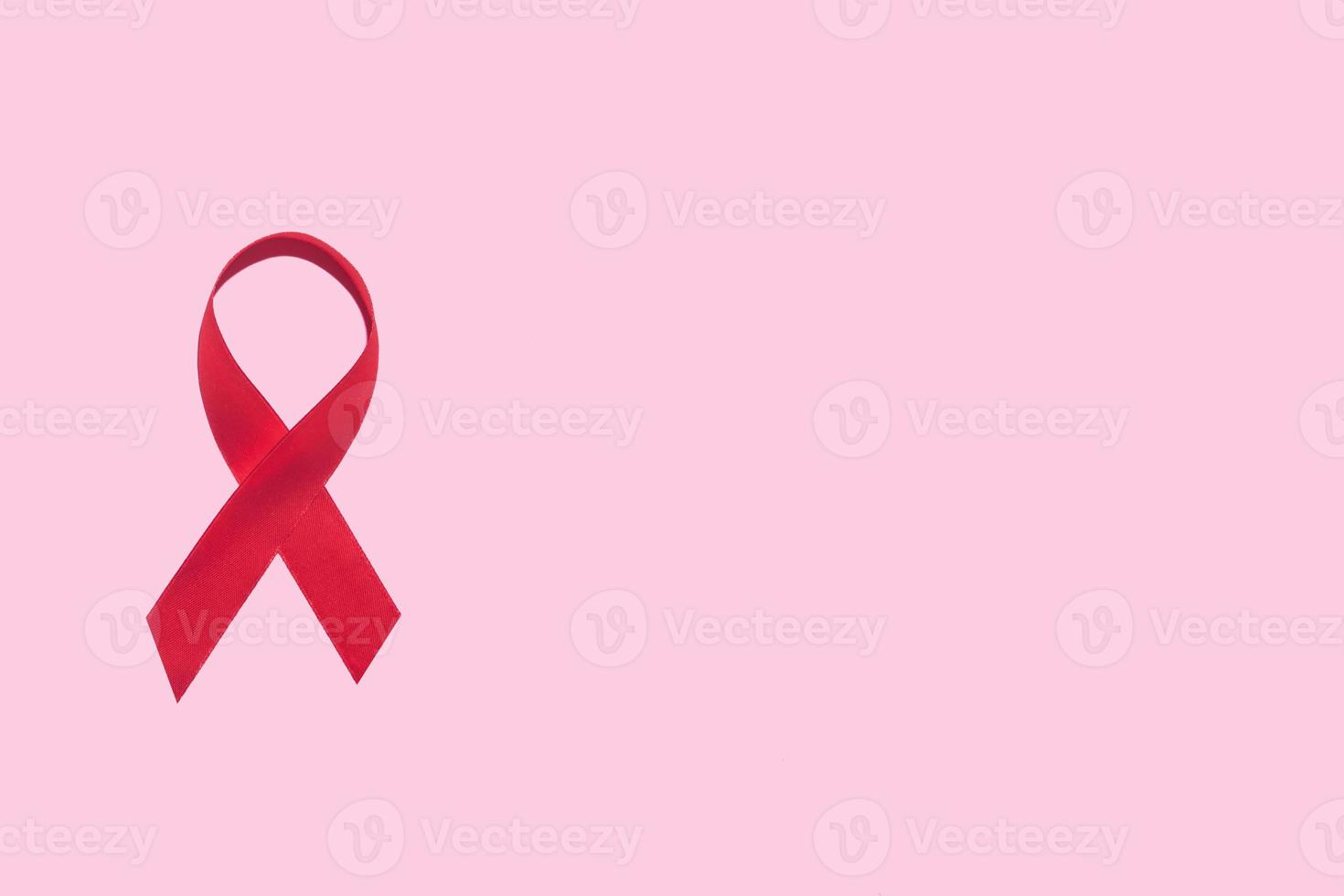 simbolo del nastro rosso della giornata mondiale contro l'AIDS su sfondo rosa foto