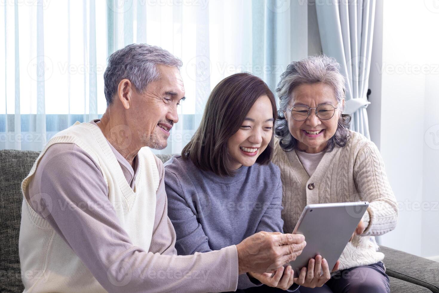 asiatico famiglia riunione di anziano padre, madre e figlia seduta su divano con contento Sorridi nel la pensione casa mentre guardare a vecchio nostalgico foto nel il passato