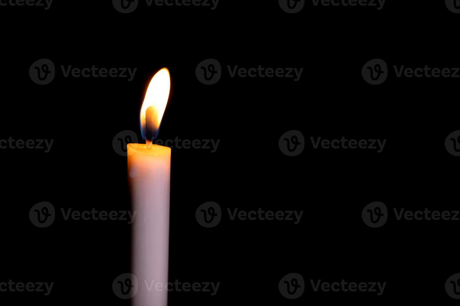 ardente bianca candela su il scuro, fiamma di candela su nero sfondo foto