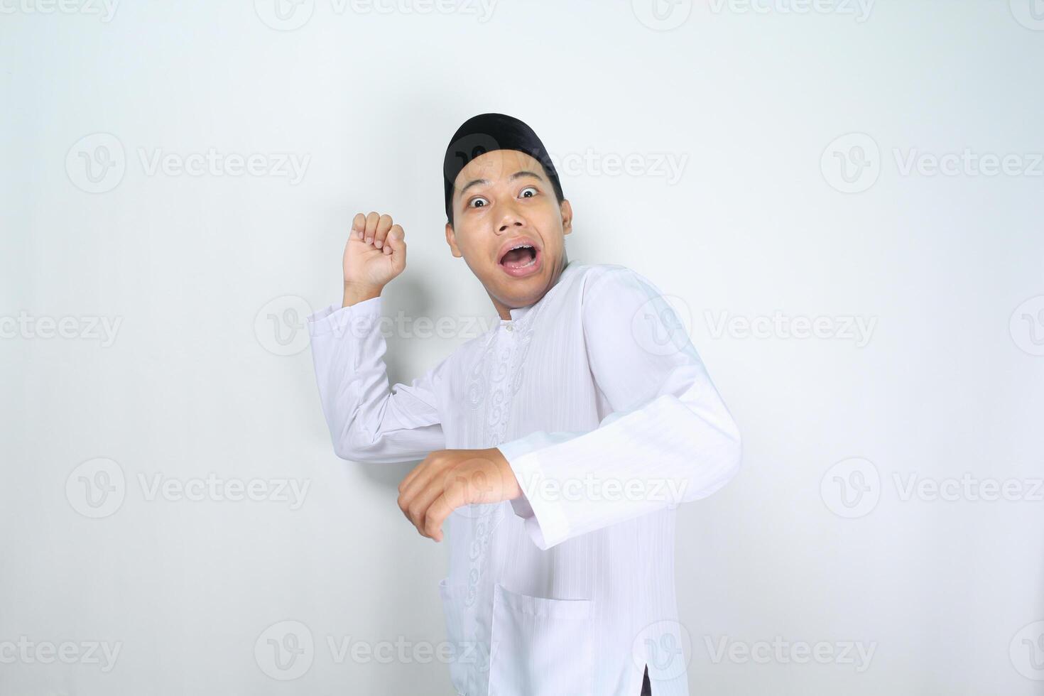divertente musulmano uomo asiatico con scioccato espressione in posa per gettare qualcosa isolato su bianca sfondo foto