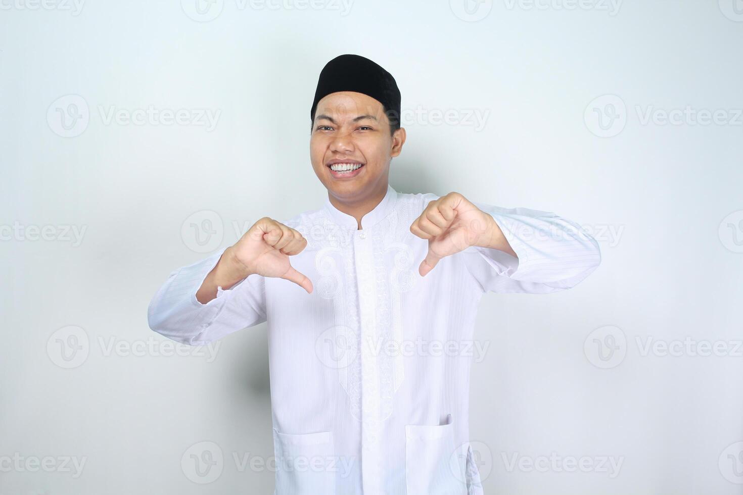 divertente musulmano asiatico uomo dando pollici giù isolato su bianca sfondo foto